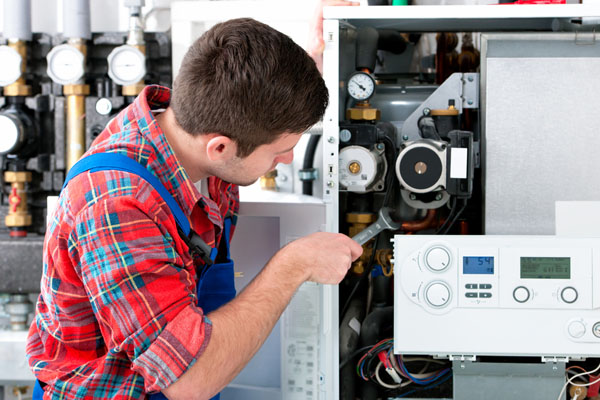 HVAC technician inspecting and repairing boiler controls in Prescott Valley
