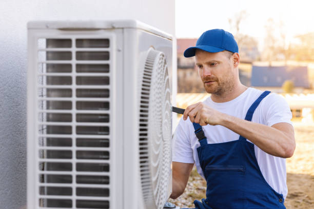 HVAC technician servicing an outdoor air conditioning unit in Prescott Valley